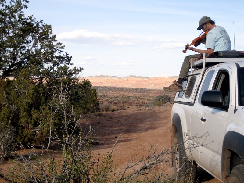 Phil Salazar playing fiddle on top of a truck in the desert
