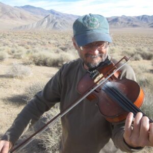 Phil Salazar playing violin in the desert